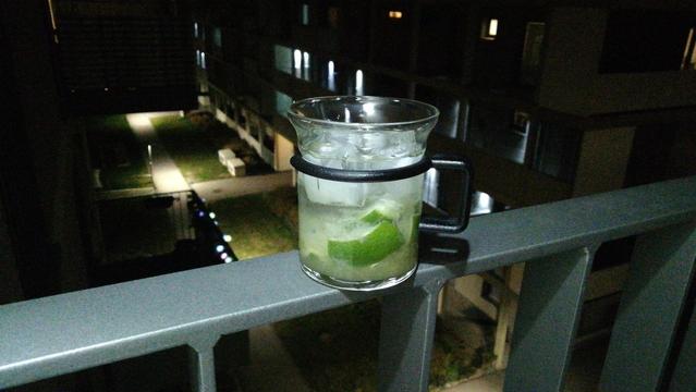A Caipirinha on top of my balcony rails, dark lit pathway in the background