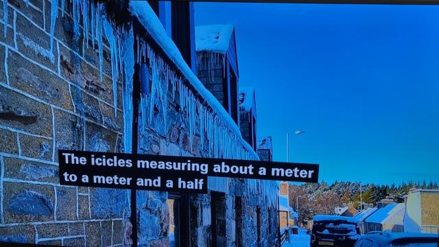 Building in Tomintoul on Main Street with large dangerous looking icicles hanging from the eaves above the pavement