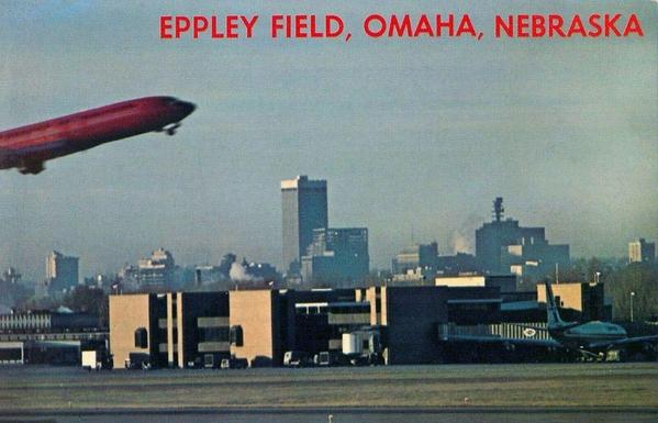 A plane take off over the terminal with the city of Omah in the back ground.