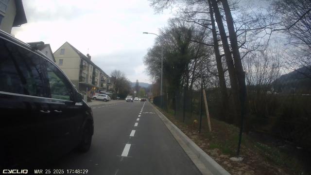 Blick einer Dashcam nach vorne. Ein PKW überholt trotz oder gerade wegen des Radfahrschutzstreifens viel zu knapp.