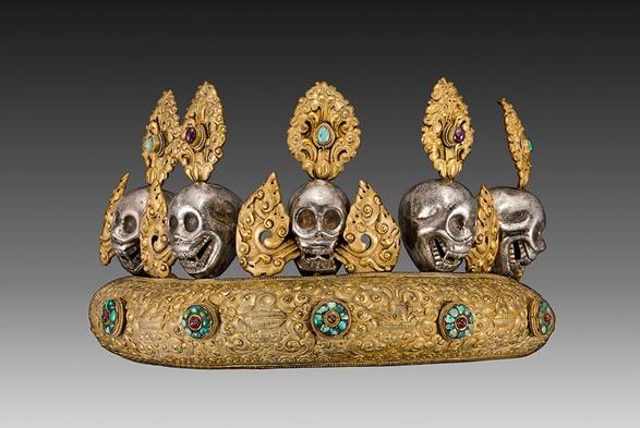 Una diadema de oro con cinco calaveras que expulsan llamas por la boca.