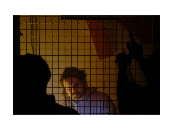young may excitedly djing at setup behind bars, hazy low key club situation