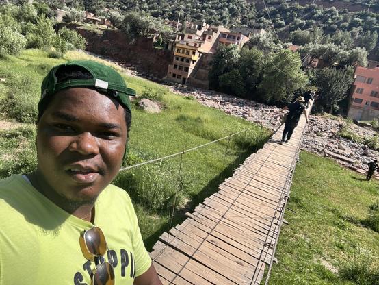 Selfie of Taslim while walking on a suspended bridge.