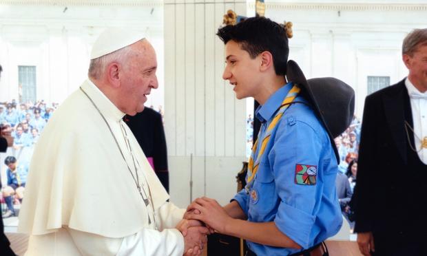 A photo of me and Papa Francesco talking. He is on the left, listening to me with a serious expression. I am on the right, in scout uniform, holding his hands.