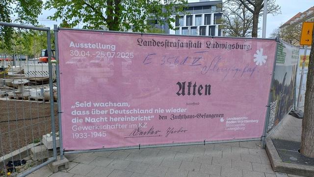Banner der Ausstellung "Seid wachsam, dass über Deutschland nie wieder die Nacht hereinbricht - Gewerkschafter im KZ 1933 - 1945" am Bauzaun vor dem Staatsarchiv Ludwigsburg