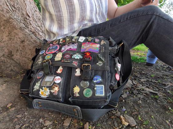 me sitting with my old bag by the river, showing the old collection (described in next post)