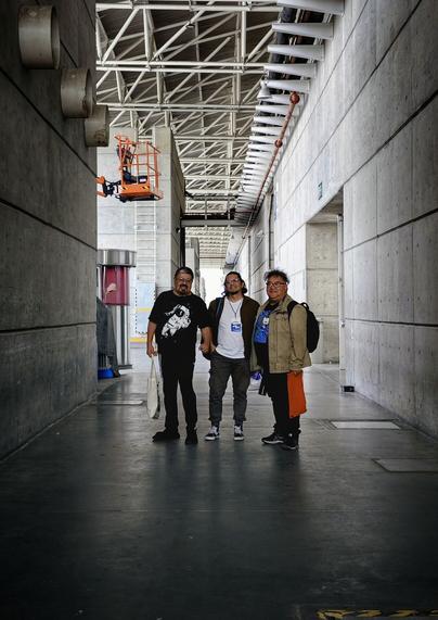 José Luis Zárate, Abraham Balcázar y Bernardo Fernández Bef, artistas mexicanos, posan en un espacio liminar, entre tubos de metal y estructuras de concreto.