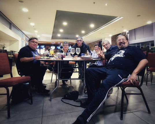 Alrededor de una mesa redonda, un grupo de hombres y mujeres miran sonriendo a la cámara. De izquierda a derecha, Bernardo Fernández Bef, Cecilia Eudave, Alberto Chimal, Cindy y Naief Yehya y José Luis Zárate.