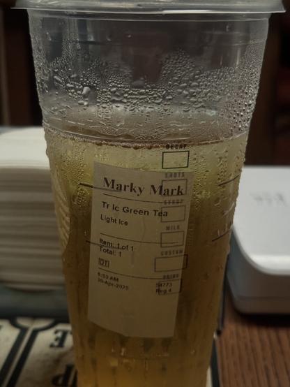 A “sweaty” trenta cup 3/4 filled with green tea, with the name Marky Mark written on it.