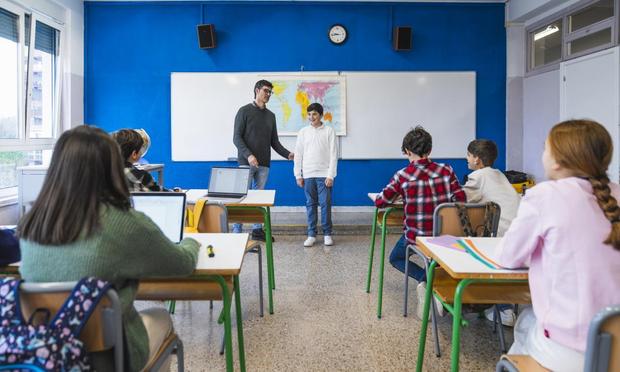 Profesor de un colegio junto a sus alumnos en una clase. (Getty Images)