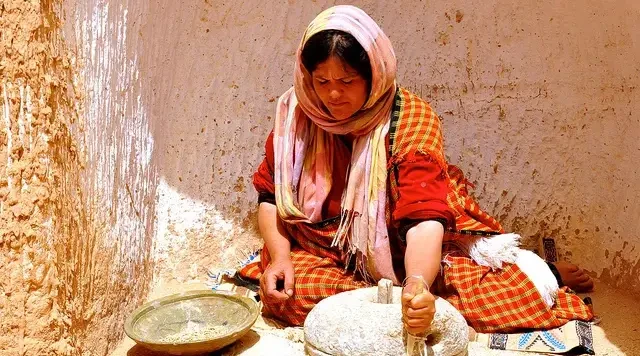 une femme utilise un broyeur en pierre au sud de la Tunisie