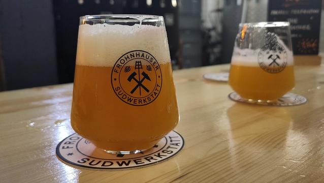 Zwei Gläser mit Bier und einer schönen Krone auf Holztisch