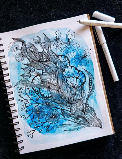 Blick auf eine Seite und zwei Finliner.  Auf der Seite ist  blauer Aquarell Hintergrund. Darauf sind mit schwarzem Finliner Fantasiepflanzen und Blüten gezeichnet.  In einem Verbund von unten rechts nach oben links.