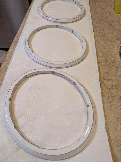 Three 3d printed ovals with notches on the inside. They are drying on paper towels