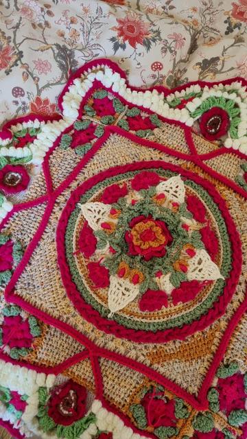 Bright pink, green, beige and white voluminous crochet pattern with flowers and geometrical figures - a closer photo