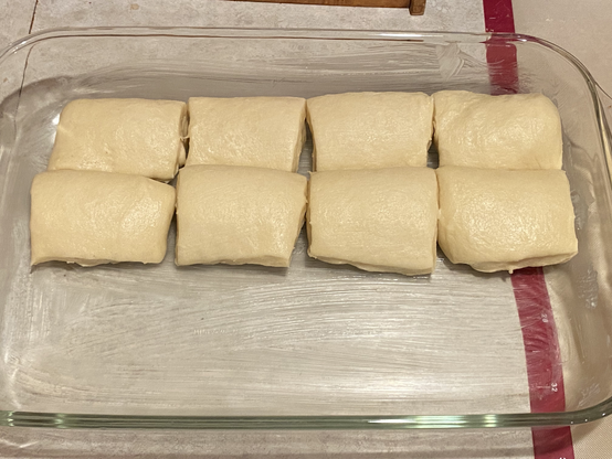 the same eight rolls after an hour or rise time. definitely puffier, it's clear in comparison against the previous photo. but they're still nowhere near the level in the recipe photo.