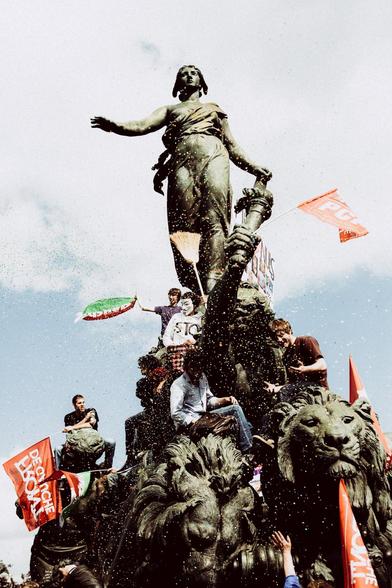 Des cotillons volent devant la statue place de la Nation, des manifestants sont grimpés un peu partout, des drapeaux rouges et verts flottent.