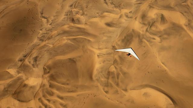 An ultralight aircraft flying over the sands of Namibia