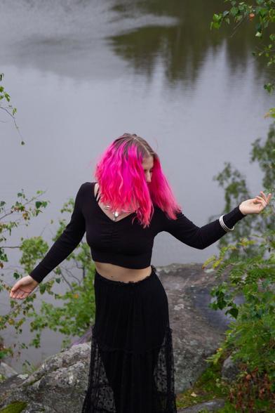 A woman dancing on ciffs in front of a river