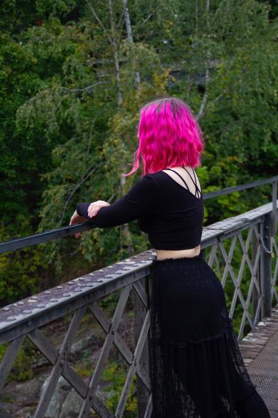 A woman leaning on bridge railing