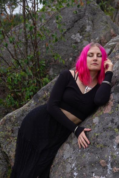 A woman laying on a cliff with her eyes closed