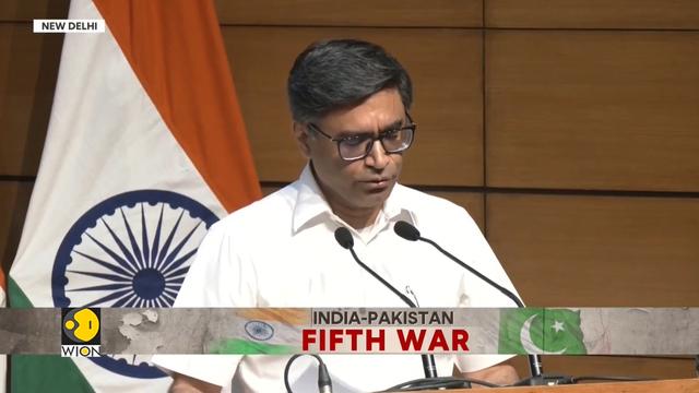Secretari d'exteriors del govern indi llegint un comunicat a la sala de premsa de les Forces Aèries Índies a Nova Delhi. Rètol de la tv WION: "India-Pakistan fifth war" (5a guerra Índia-Pakistan).