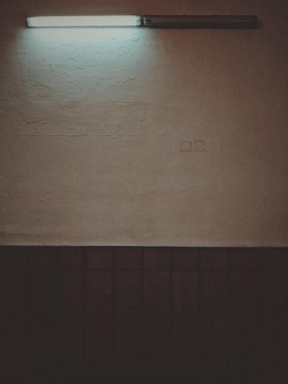 Two lamps next to each other on a station wall. The one on the left works, the one on the right remains dark.
