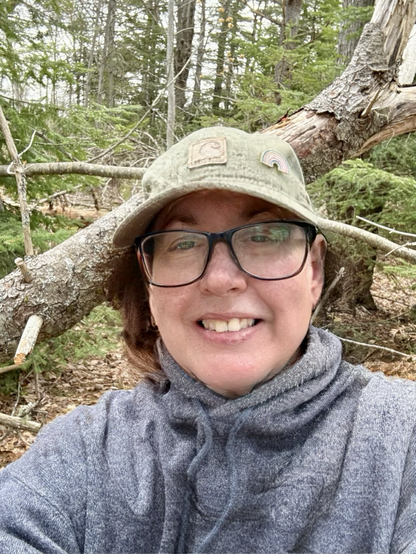A photo of a trans woman in the woods