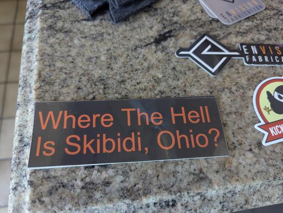 A close up of a sticker that says "where the hell is Skibidi, Ohio?"