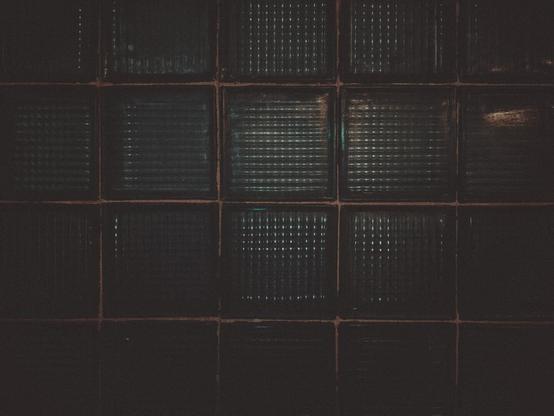 Close-up of a dark green glass stone window.