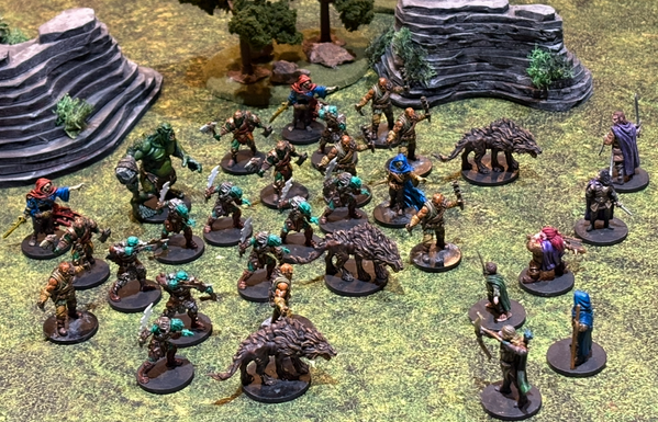 A whole lot of orcs and wargs and a wandering troll accosting the fellowship in a rocky pine wood