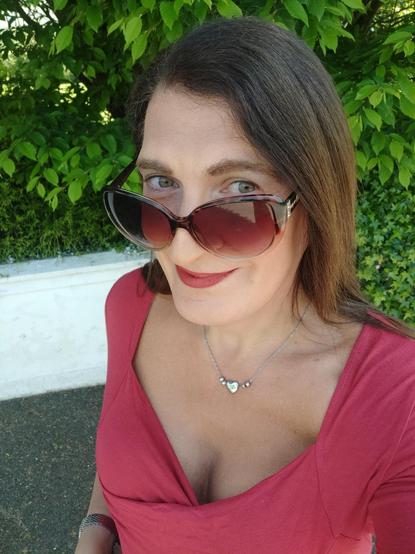 A selfie of a brunette woman in a red top