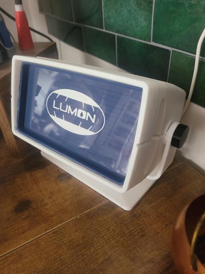 Same console but with my e-reader removed. I painted the back of the console navy, white sticker of the Lumon logo in the center. A perfectly cut transparency sheet to fit into it to make it look like a monitor.