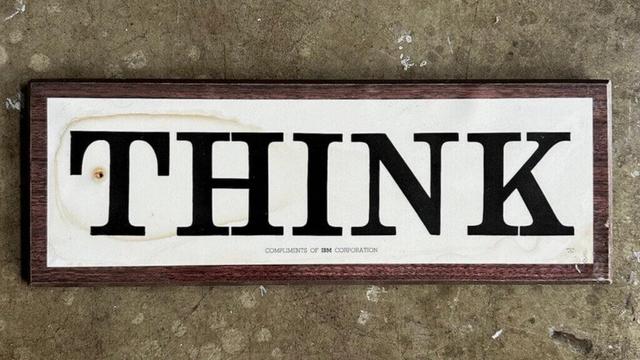 Tame the creative mind! Photograph of a 1960s IBM Corporation wooden wall sign laminated plaque with the word "THINK" in large letters and the phrase "COMPLIMENTS OF IBM CORPORATION" in small letters underneath.