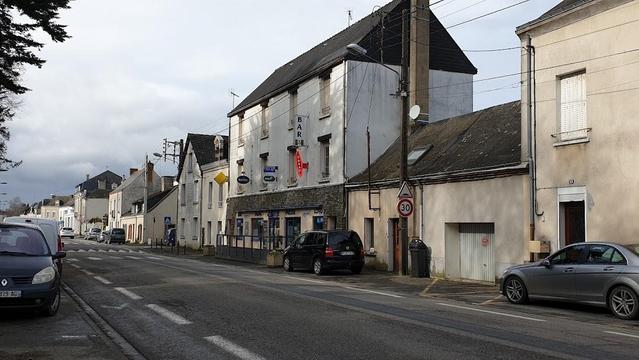 Street scene in a French town, cars parked alongside buildings.