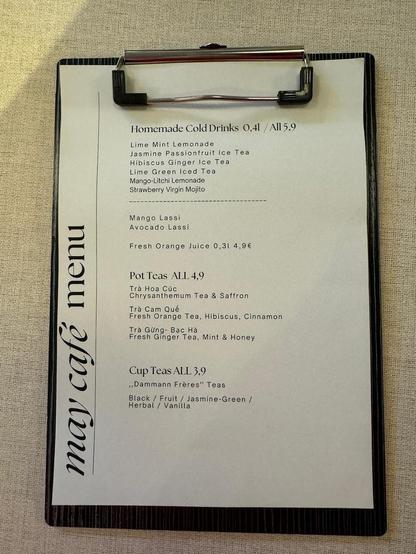 A clipboard displays a menu with homemade cold drinks, pot teas, and cup teas, including options like Lime Mint Lemonade, Chrysanthemum Tea, and "Dammann Frères" Teas.