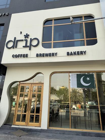 The facade of "drip" cafe featuring a Pakistani flag in the window.