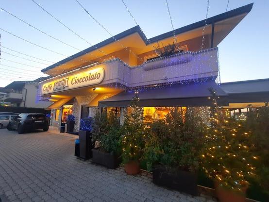 Illuminated "Caffe Slim Cioccolato" building.