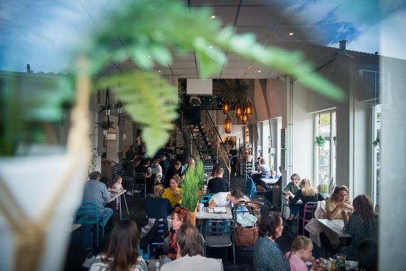 A busy cafe scene with people dining.