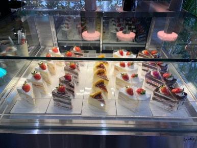 A display case is filled with delicious-looking cakes topped with strawberries.