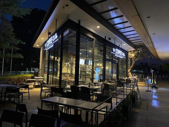The Coffee Club, cafe-and-restaurant, in an outdoor setting at night. Tables and chairs are placed outside.