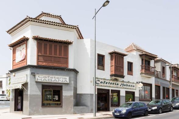 A building with "Cafeteria Habana" signs and traditional wooden balconies.