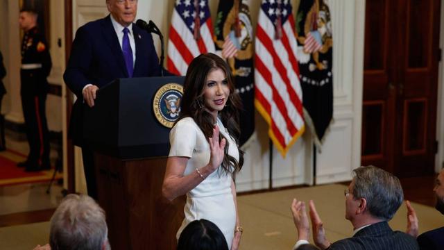 Kristi Noem stands in front of President Donald Trump during the signing ceremony for the Laken Riley Act on Jan. 29, 2025 in Washington, D.C.