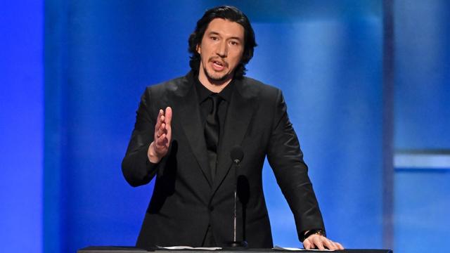 Adam Driver speaks at a podium.