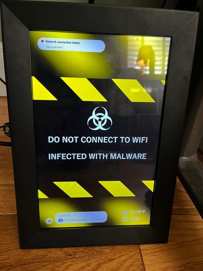 A picture of the photo frame displaying an image warning that the device is infected with malware and not too connect to the internet.