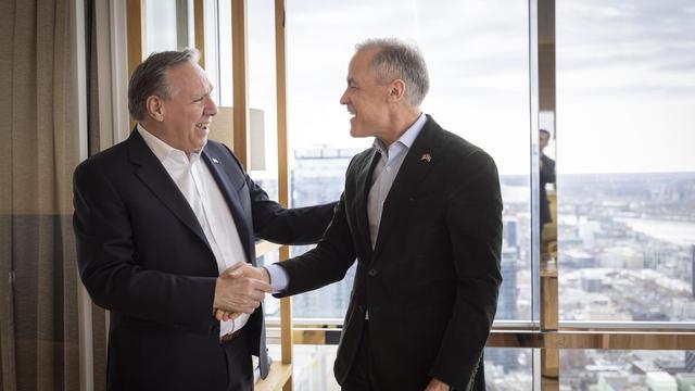 François Legault et Mark Carney se serrent la main et sourient.