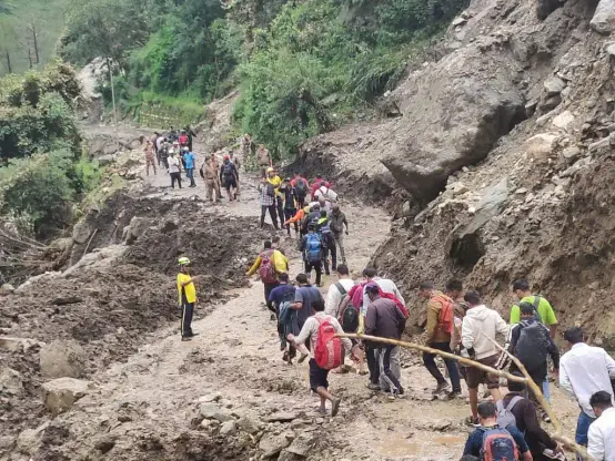 Pedestrians going through the damaged Yamunotri National Highway.
