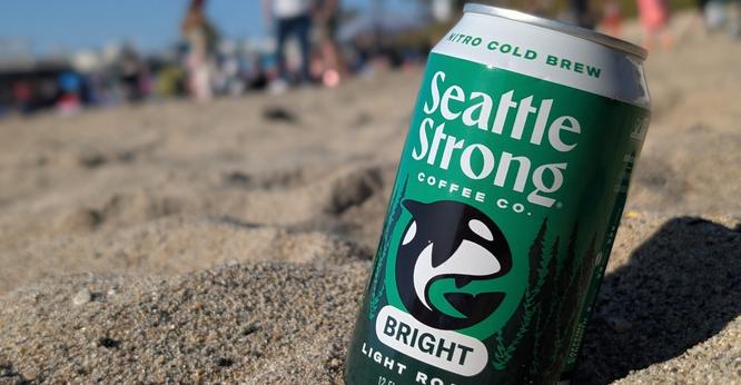 A can of cold brew sitting on the beach.