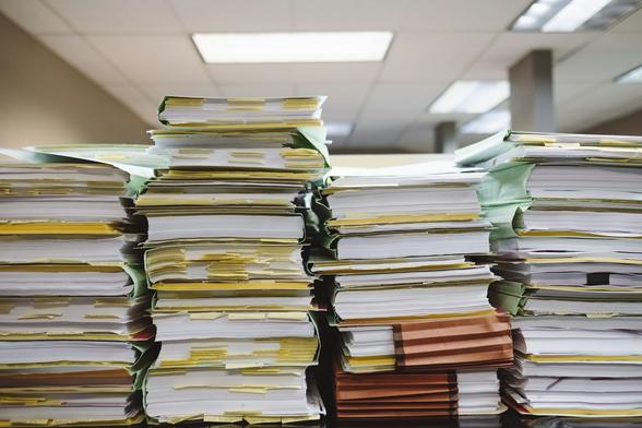 Stacks of paper files in an office (Wesley Tingey/Unsplash)