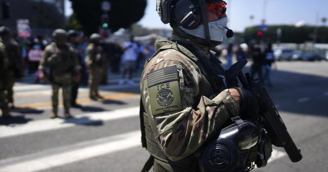 An ICE Special Response Team member stands guard outside the Metropolitan Detention Center, while protesters gather outside to denounce the ICE, U.S. Immigration and Customs Enforcement, operations, Tuesday, June 10, 2025, in downtown Los Angeles. (AP Photo/Eric Thayer)